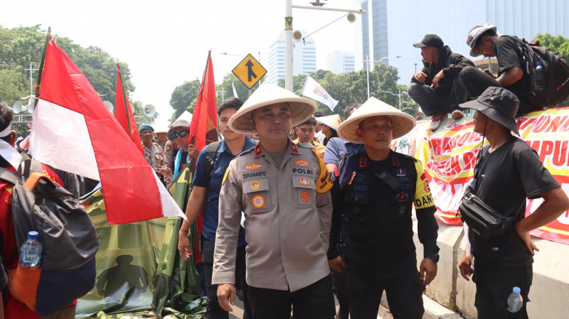 Peringati Hari Tani Nasional, Polisi Potong Tumpeng Bersama Massa Aksi di Jalan Merdeka Selatan Jakarta